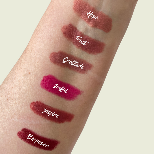 An arm swatch of various lipsticks in different shades.